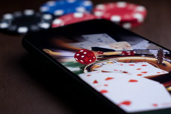 Một người phụ nữ quyến rũ cầm chip casino trong không gian ánh đèn rực rỡ, đại diện cho bầu không khí casino trực tuyến của AO88WIN.